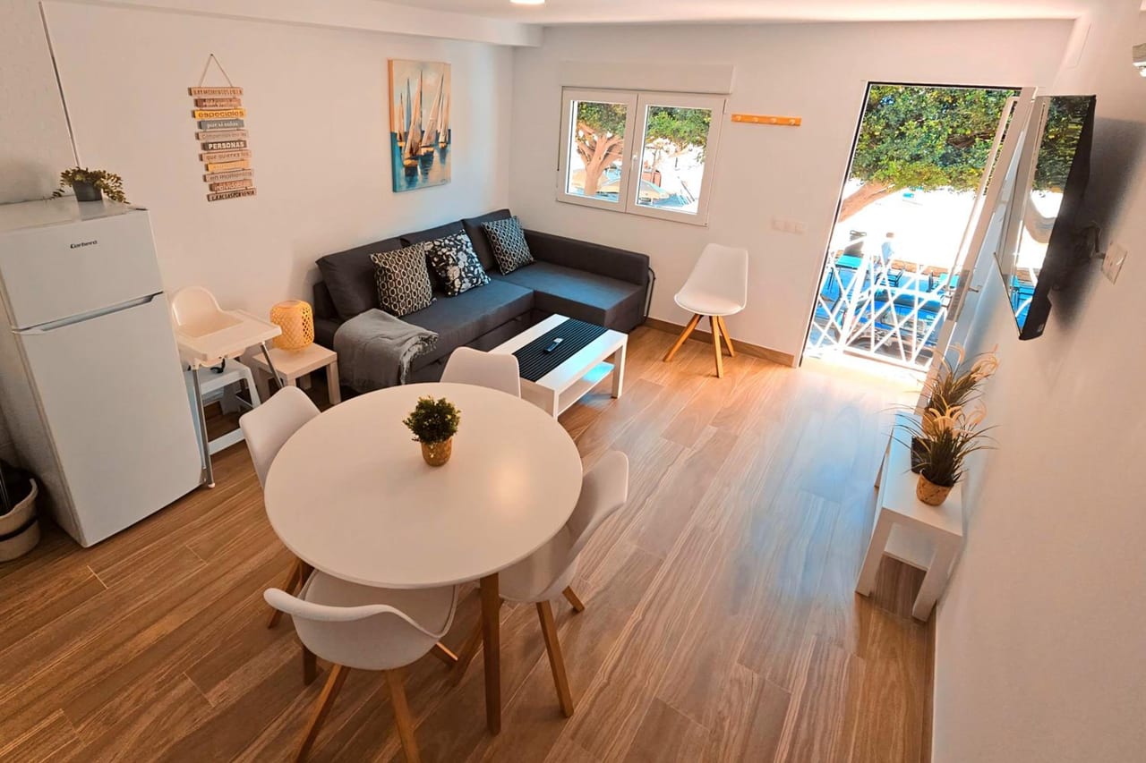 a living room with a table and a couch at La casita de Mercedes in Málaga