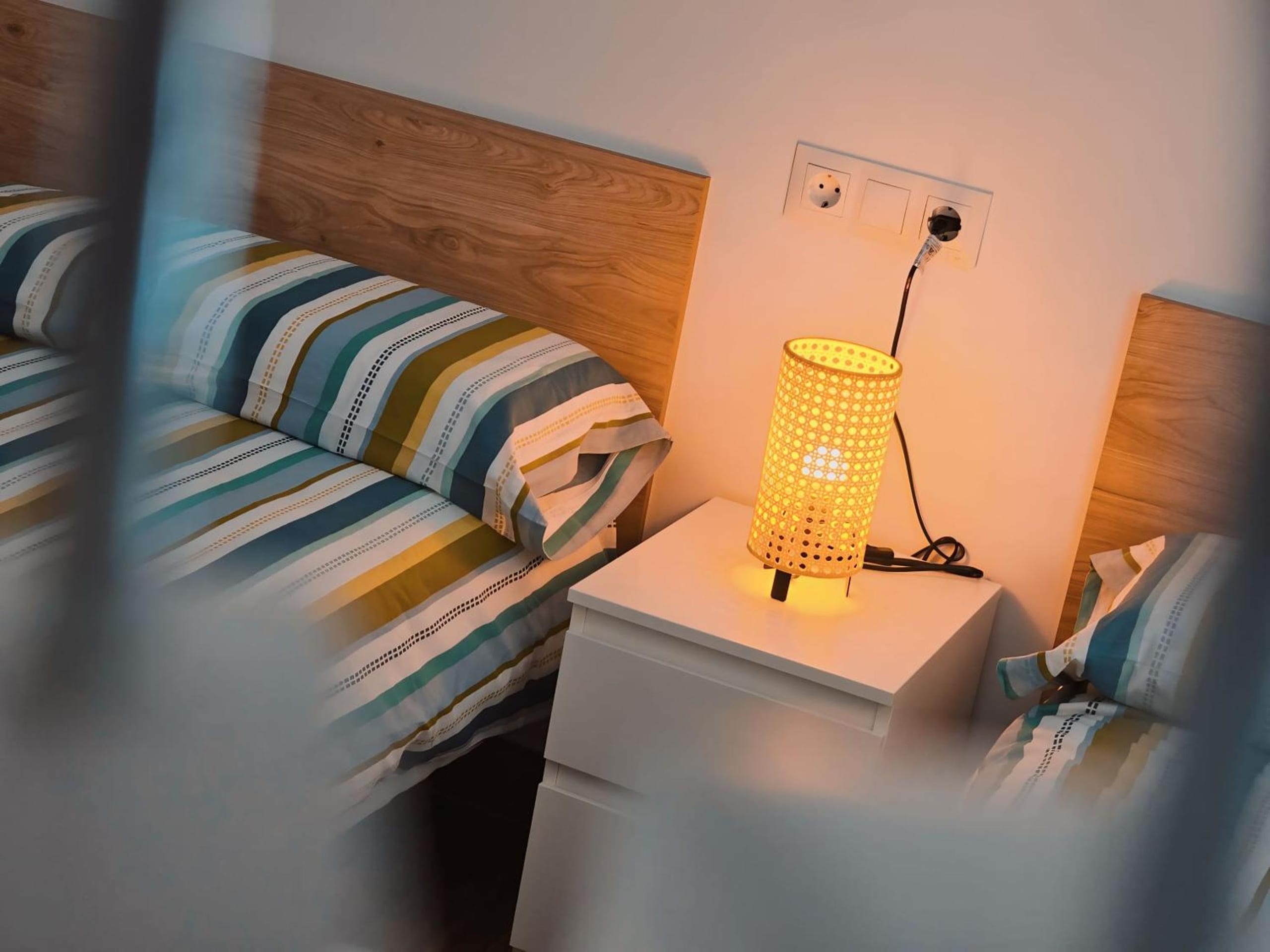 a bedroom with a bed and a lamp on a dresser at La casita de Mercedes in Málaga